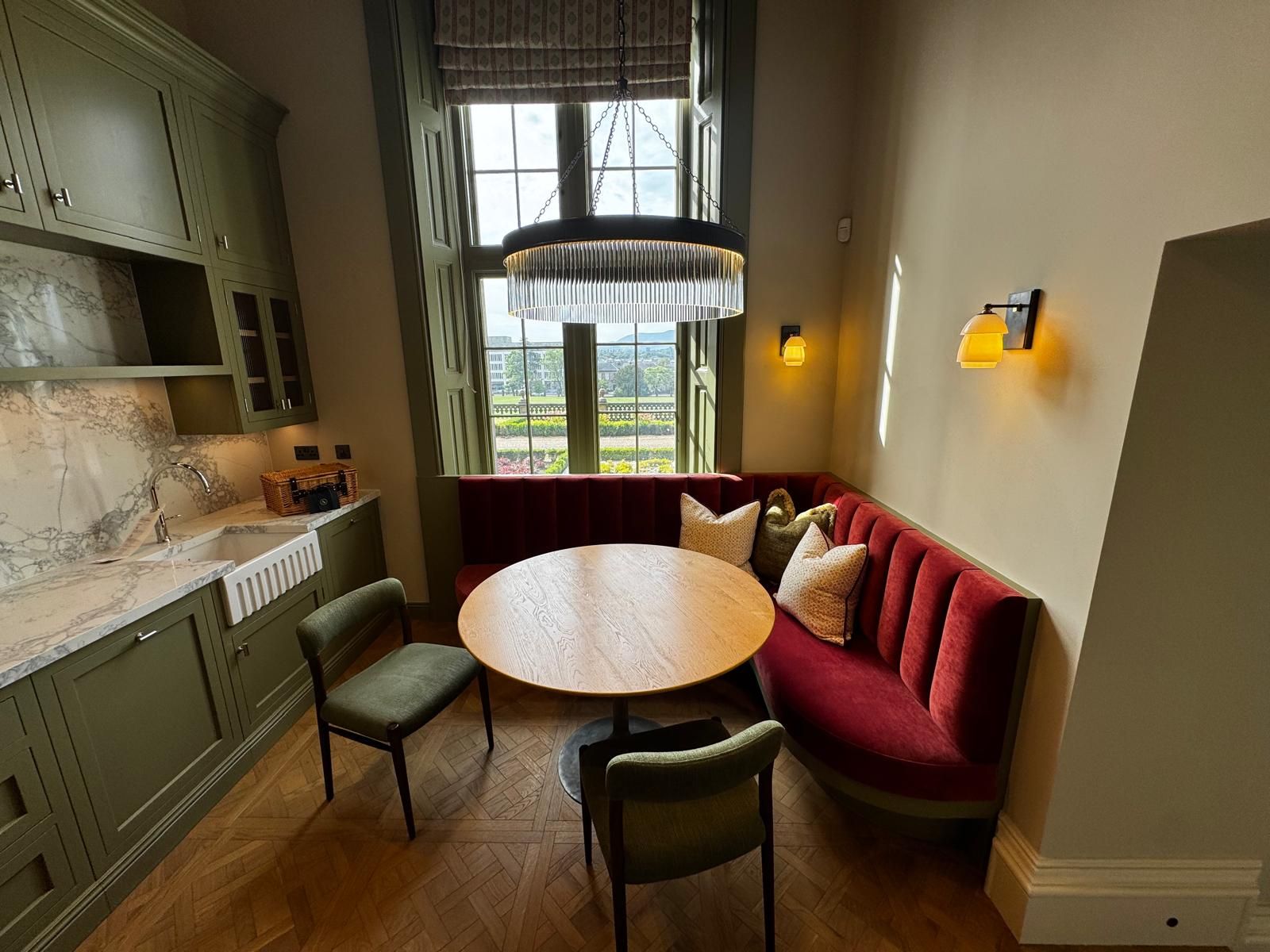 Panelled dining nook with brass wall lights and a pendant over a round table