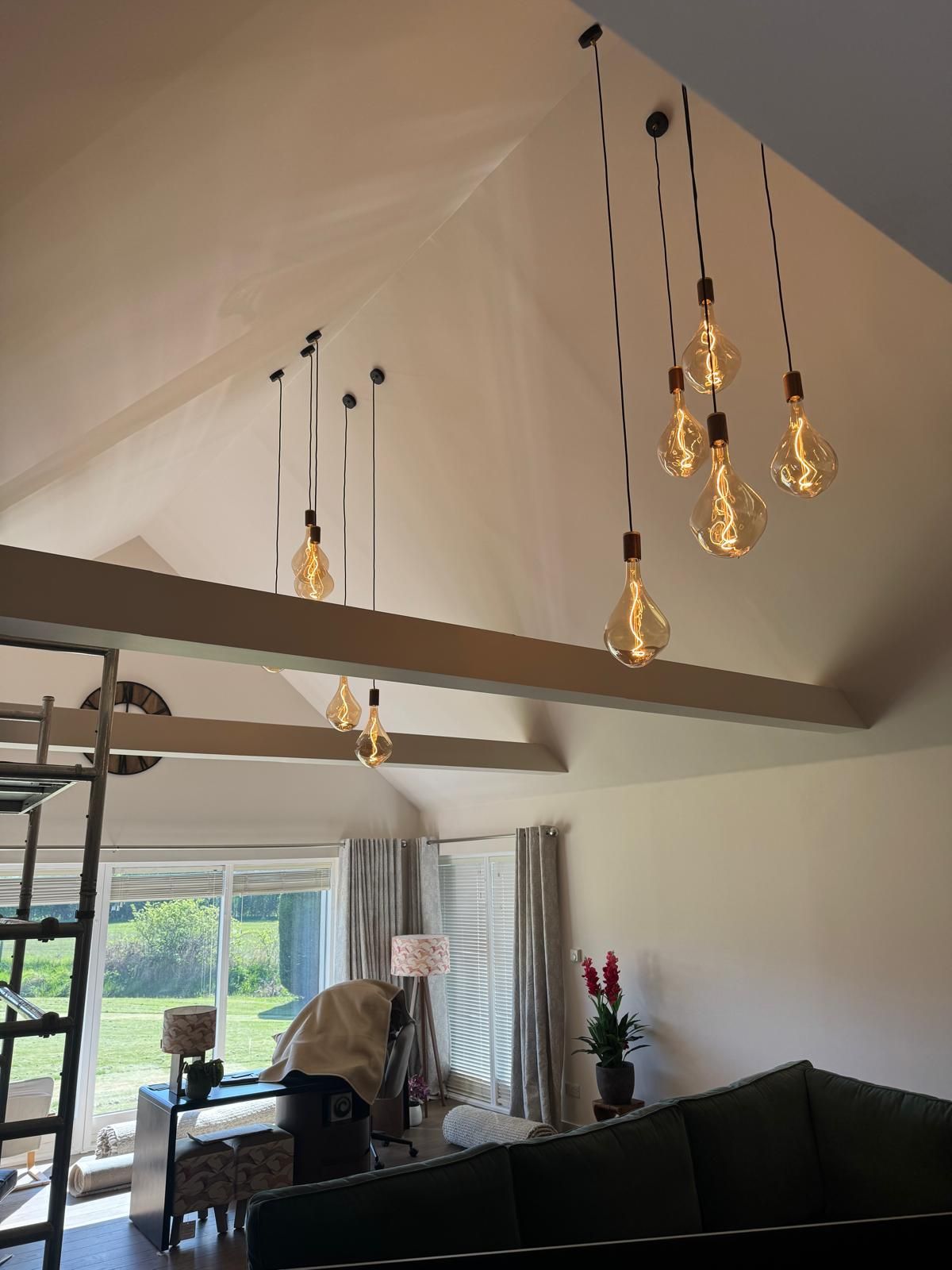 Vaulted living room with a cluster of filament pendant lights