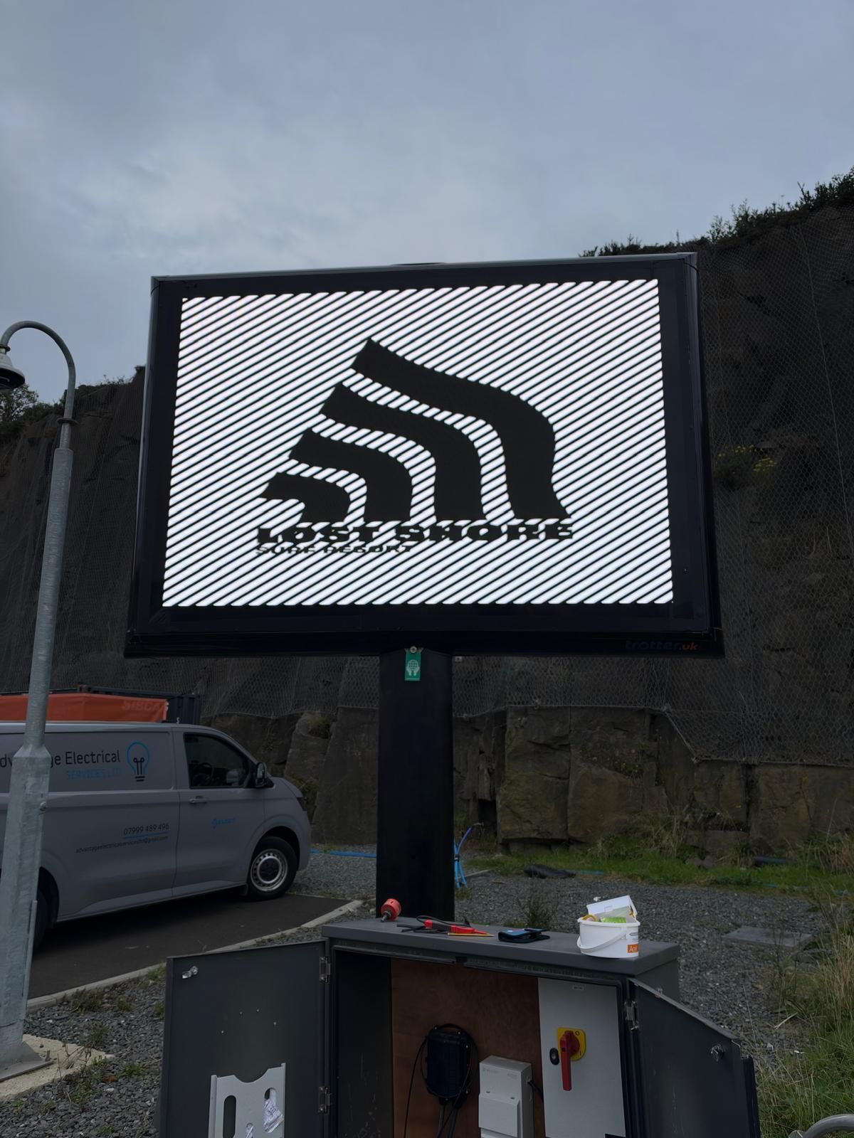 Illuminated roadside sign powered from a new feeder pillar