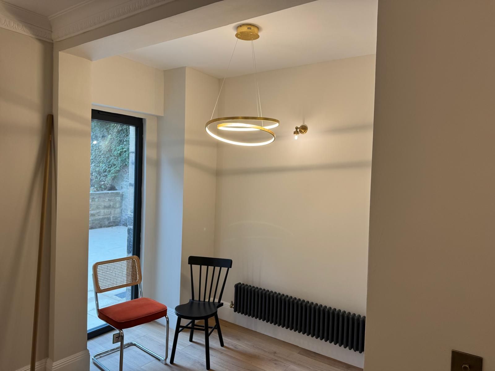 Room with a brass ring pendant and matching wall light